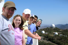 A group of IU astronomy students pose with observatories in background.